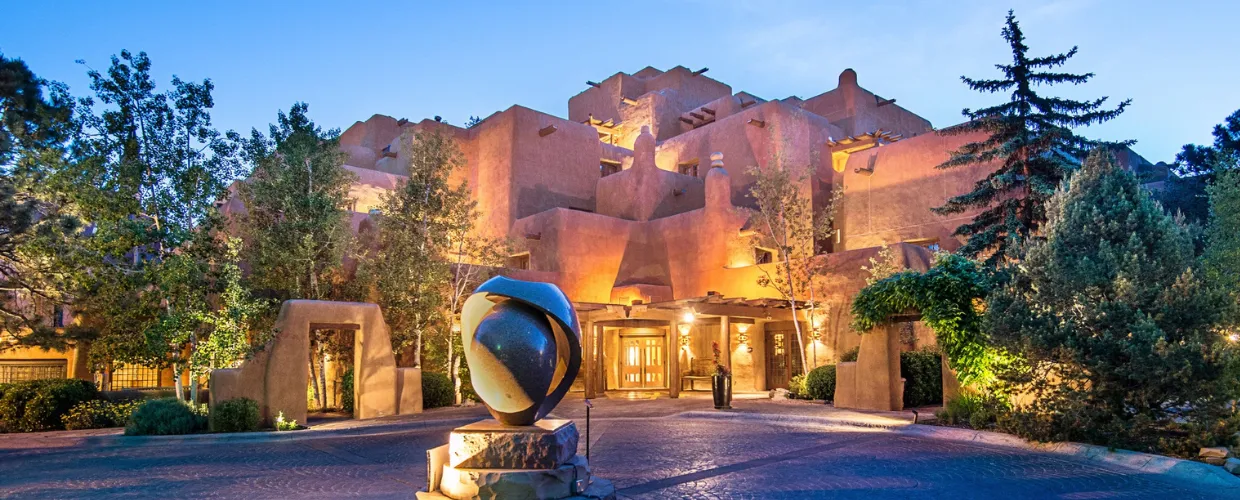 The front of a beautiful Heritage Hotel resort in New Mexico against a blue sky.