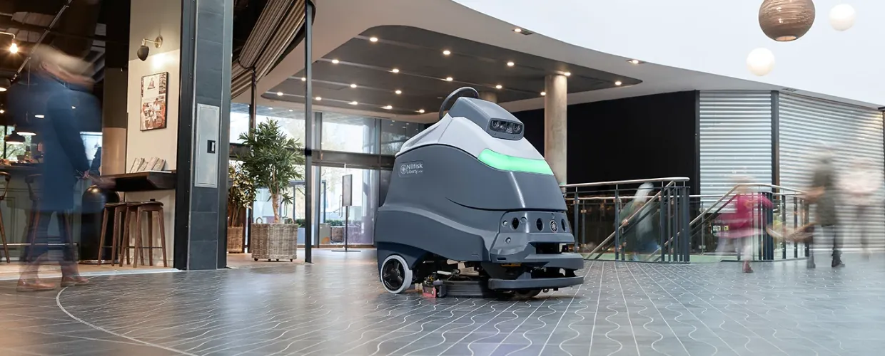 A floor-cleaning robot outside a restaurant cleans floors in a mall.